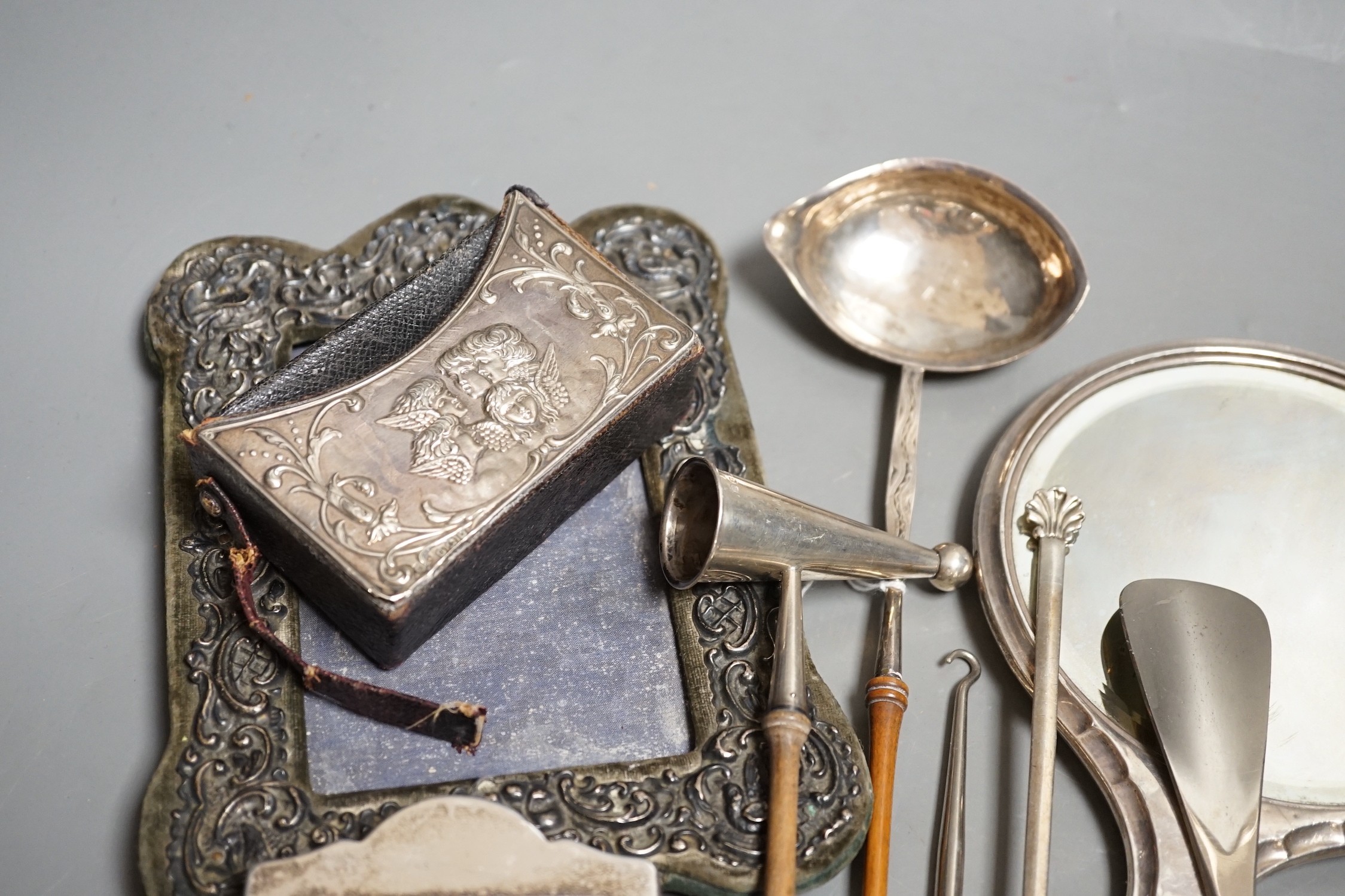 A group of small silver including two mounted photograph frames, one Birmingham, 1901, a mounted bible case, candlestick snuffer, coaster, etc.